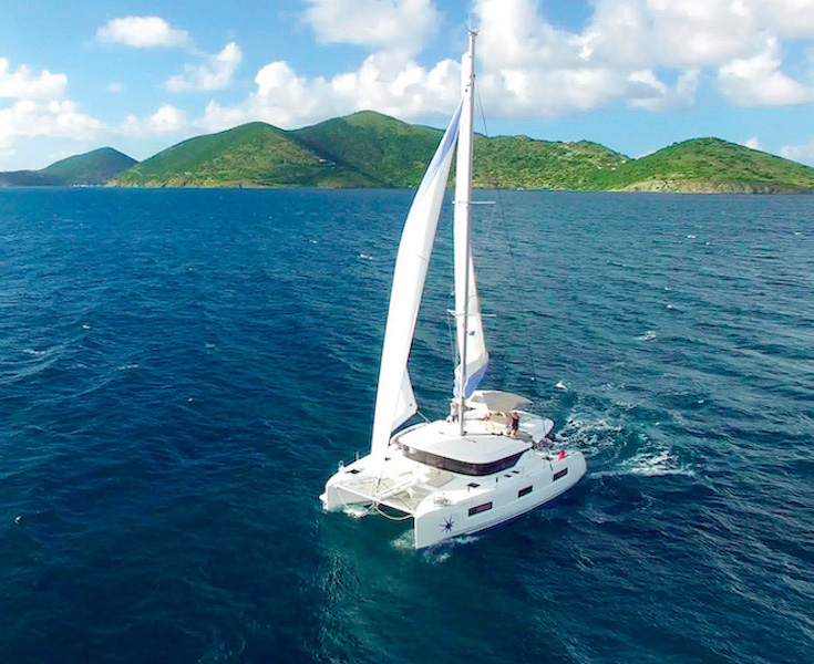 Image of a boat on the open water with sails open.